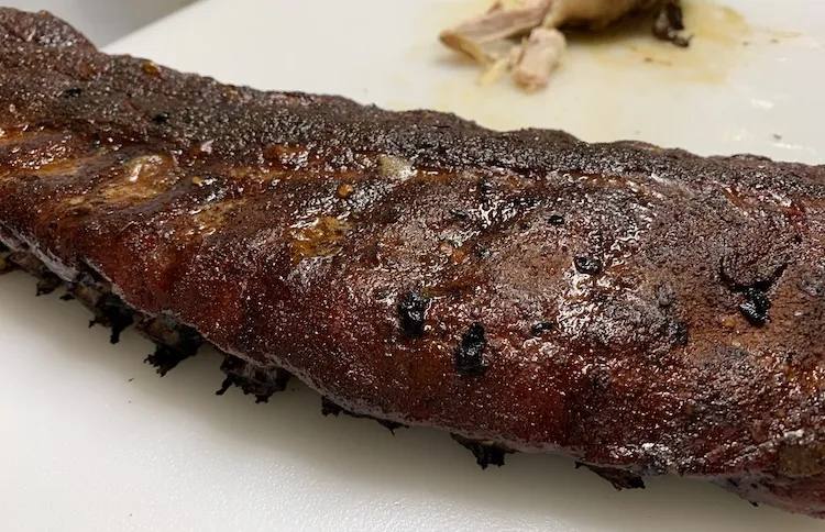 cooked slab of ribs on a white plate